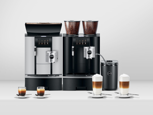 Two Jura coffee machines with lattes and espressos in front of them
